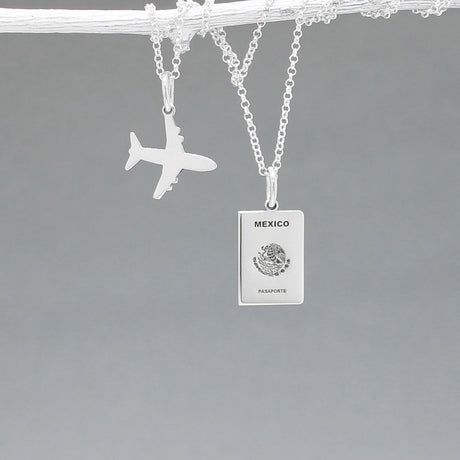 Our Mexican Passport Mini Replica Silver Pendant captures the intricate details of a Mexican passport cover, meticulously crafted from sterling silver with a high-polished finish.  Dimensions: Passport: 10mm wide by 14mm high; Airplane: 14mm wide by 14mm high. Bail: Fits up to a 2.5mm chain for versatile wear. Chain: Includes a 1.4mm sterling silver belcher Rolo chain, available in various lengths.