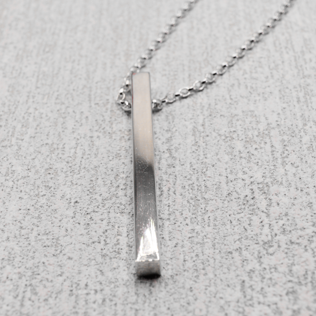 Discover the timeless elegance and captivating beauty of the EIRE - Ogham Grá & Wild Atlantic Way High Polished Bar Silver Pendant. Boasting a 3.5mm width and 40mm length, it's laser engraved with Ogham Grá on one side and the Wild Atlantic Way symbol on the other. Show off your love for the Wild Atlantic Way with its adjustable silver rolo chain stretching from 18" to 20", offering virtually endless styling possibilities!