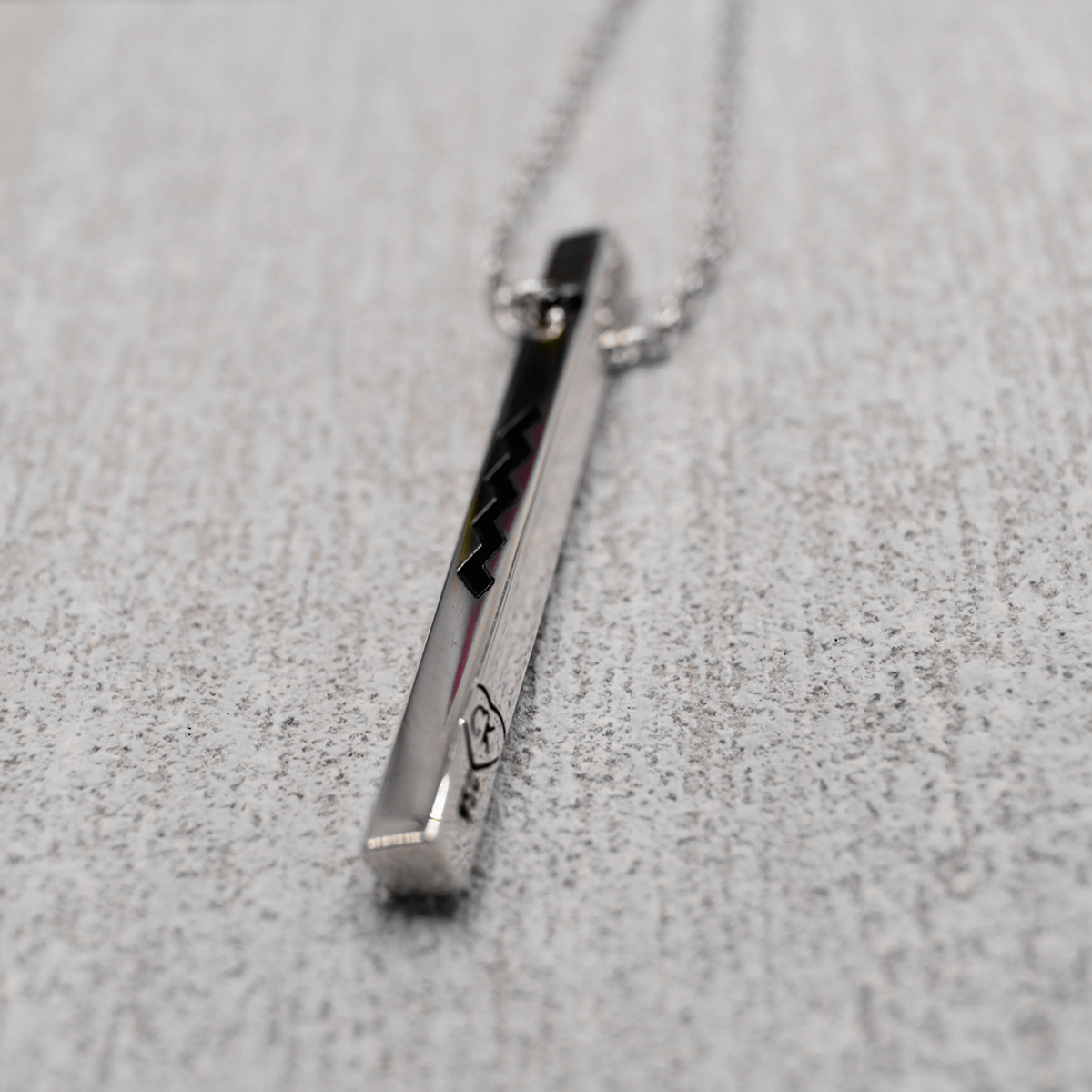 Discover the timeless elegance and captivating beauty of the EIRE - Ogham Grá & Wild Atlantic Way High Polished Bar Silver Pendant. Boasting a 3.5mm width and 40mm length, it's laser engraved with Ogham Grá on one side and the Wild Atlantic Way symbol on the other. Show off your love for the Wild Atlantic Way with its adjustable silver rolo chain stretching from 18" to 20", offering virtually endless styling possibilities!
