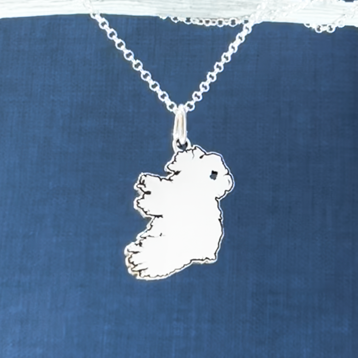 Experience the captivating allure of Ireland with the EIRE - Map with outline Of Ireland Pendant. The pendant measures 15mm by 23mm and has a bail that fits up to a 3mm chain. It also includes a 1.4mm silver rolo chain that can be effortlessly adjusted from 16" to 18". This exquisite pendant celebrates the magic of Ireland, making it an essential addition to any jewellery collection.