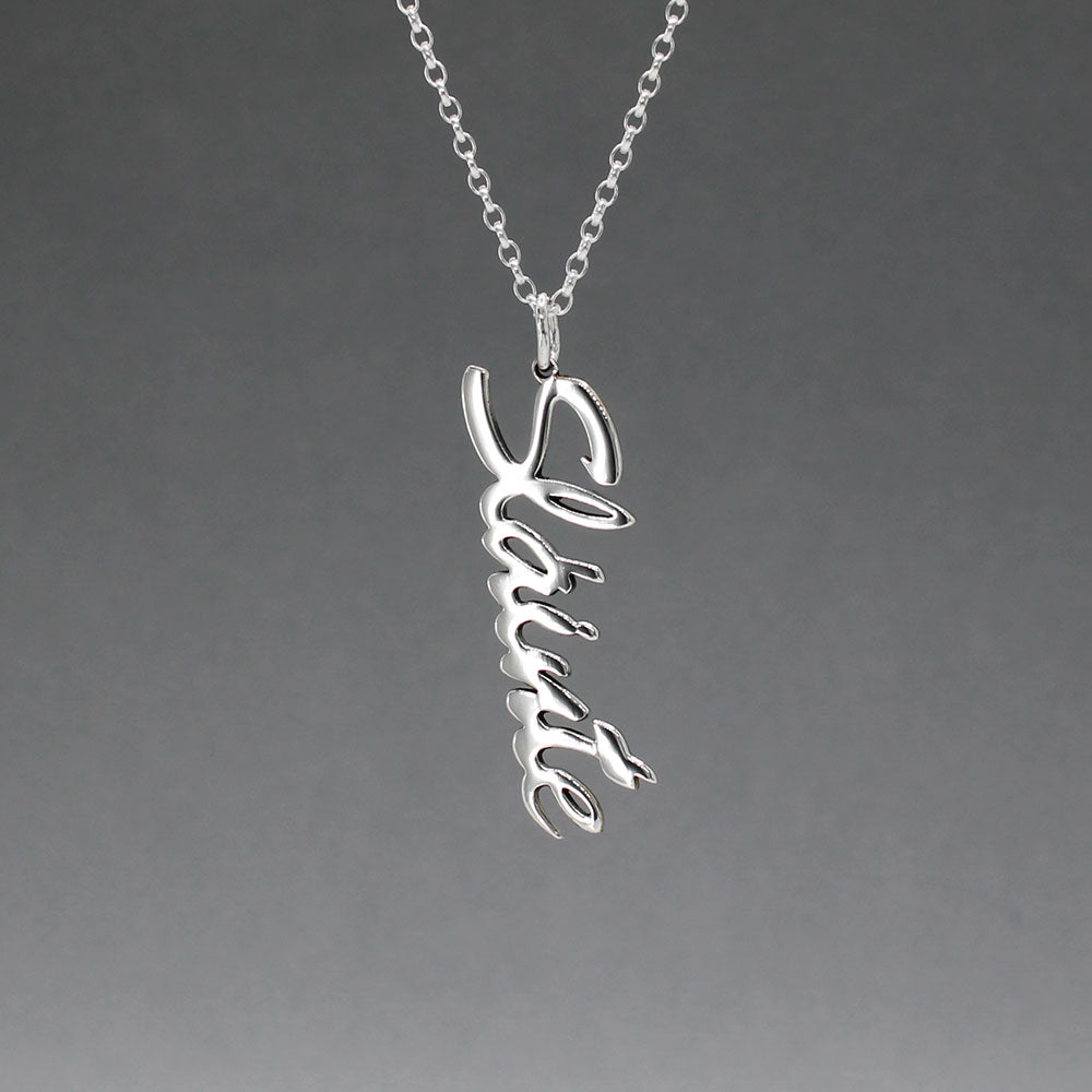 Eire - Sláinte (Health) Silver Pendant  Dimensions: 12mm wide x 37mm long, 1mm thick Chain: 1.7mm sterling silver rolo chain included Material: Made with sterling silver Design: Featuring the word "Sláinte" in italic font Style: Unisex Celebrate health and well-being with our elegant Eire - Sláinte Silver Pendant. This beautifully crafted piece is perfect for anyone who appreciates fine Irish jewellery. Select chain length below.