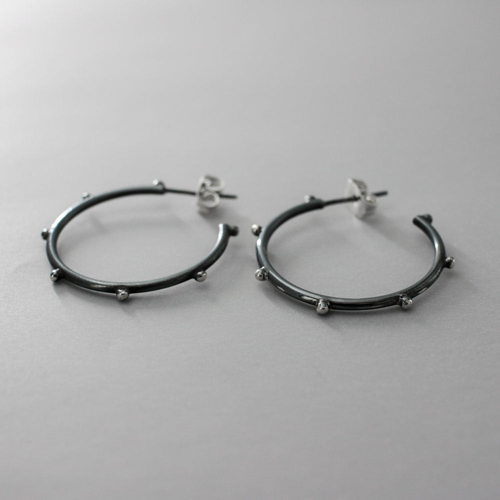 These elegant hoop earrings feature a stylish dot design, crafted with precision from high-quality sterling silver. The oxidised finish adds a unique touch of sophistication, making them perfect for any occasion. Silver jewellery Ireland.