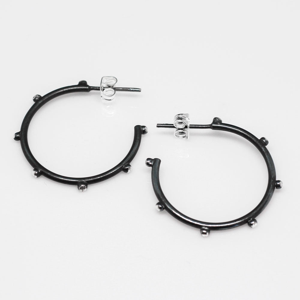 These elegant hoop earrings feature a stylish dot design, crafted with precision from high-quality sterling silver. The oxidised finish adds a unique touch of sophistication, making them perfect for any occasion. Silver jewellery Ireland.