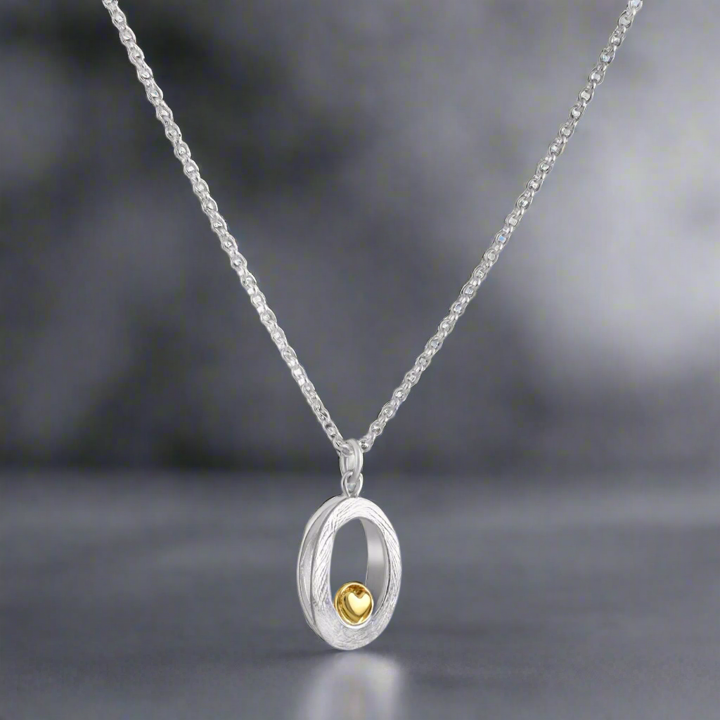 Celebrate life’s most treasured connections with this stunning pendant, featuring a 9ct golden heart nestled in textured sterling silver. Designed to capture the essence of love and care, this piece offers a modern take on meaningful Irish jewellery. Garrett Mallon - Embrace Heart Silver and Gold Pendant.