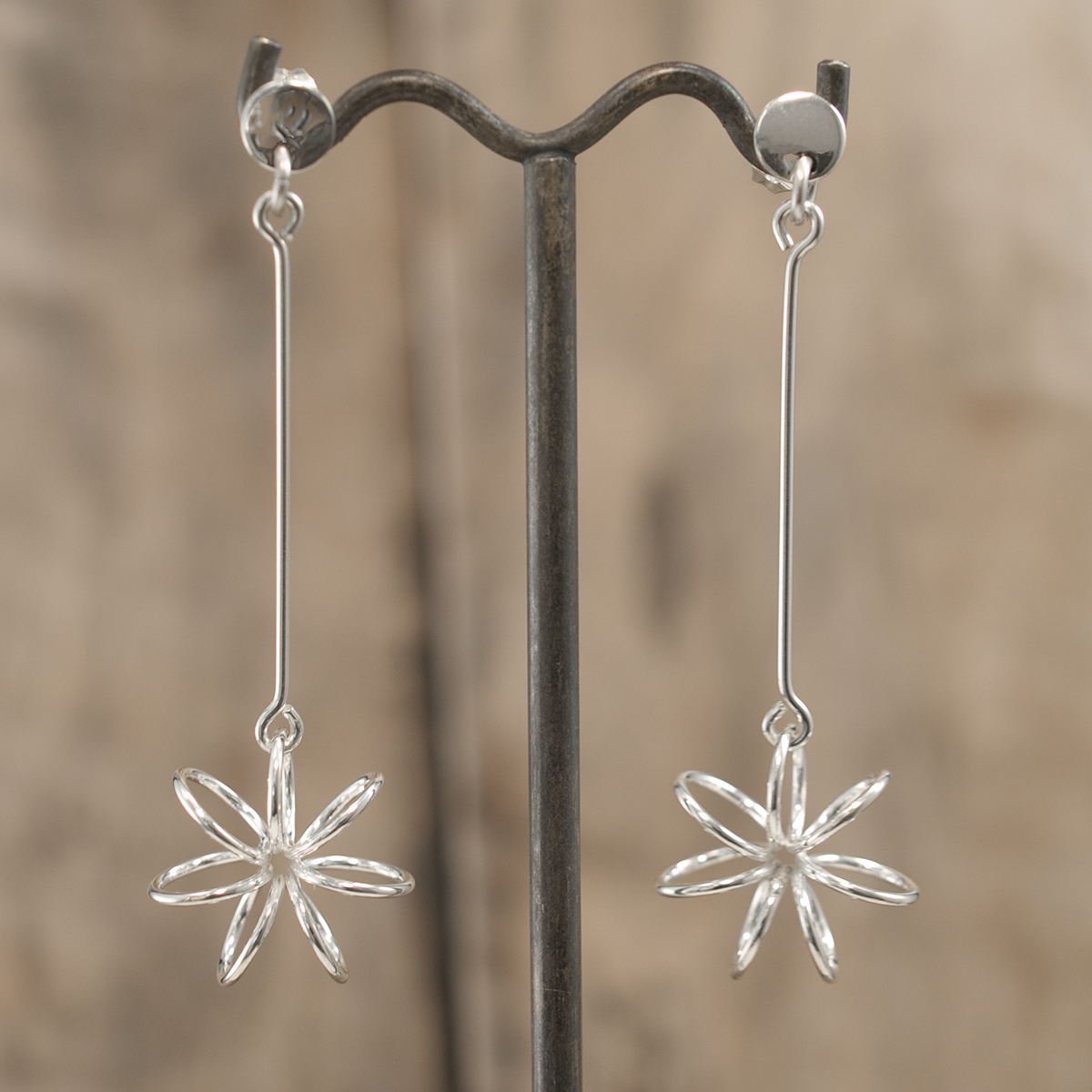 Moineir Floating Flower Silver Earrings - Studs: where whimsy meets elegance in stunning craftsmanship. Handcrafted from .925 sterling silver, these earrings feature a charming 14mm flower on a slim 36mm stem, they strike a perfect balance between subtlety and statement. With a secure friction back, they're comfortable for day-to-night wear.&nbsp;