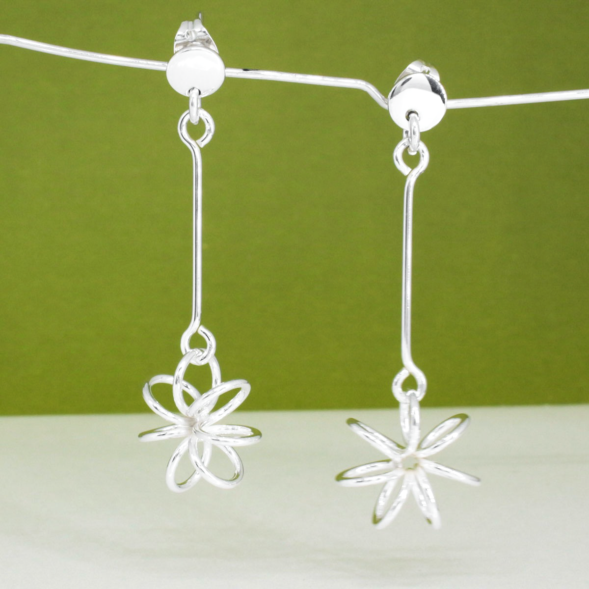 Moineir Floating Flower Silver Earrings - Studs: where whimsy meets elegance in stunning craftsmanship. Handcrafted from .925 sterling silver, these earrings feature a charming 14mm flower on a slim 36mm stem, they strike a perfect balance between subtlety and statement. With a secure friction back, they're comfortable for day-to-night wear.&nbsp;