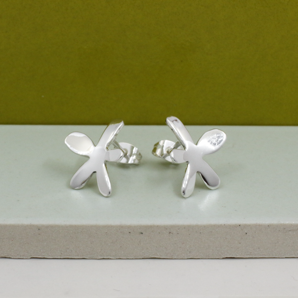 These exquisite Moineir - Small Silver Happy Daisy Earrings - Stud are 17 MM in length and 14 MM in width (equivalent to 11/16 inches by 9/16 inches). Made with .950 sterling silver, these earrings feature a high polished silver finish and friction post.