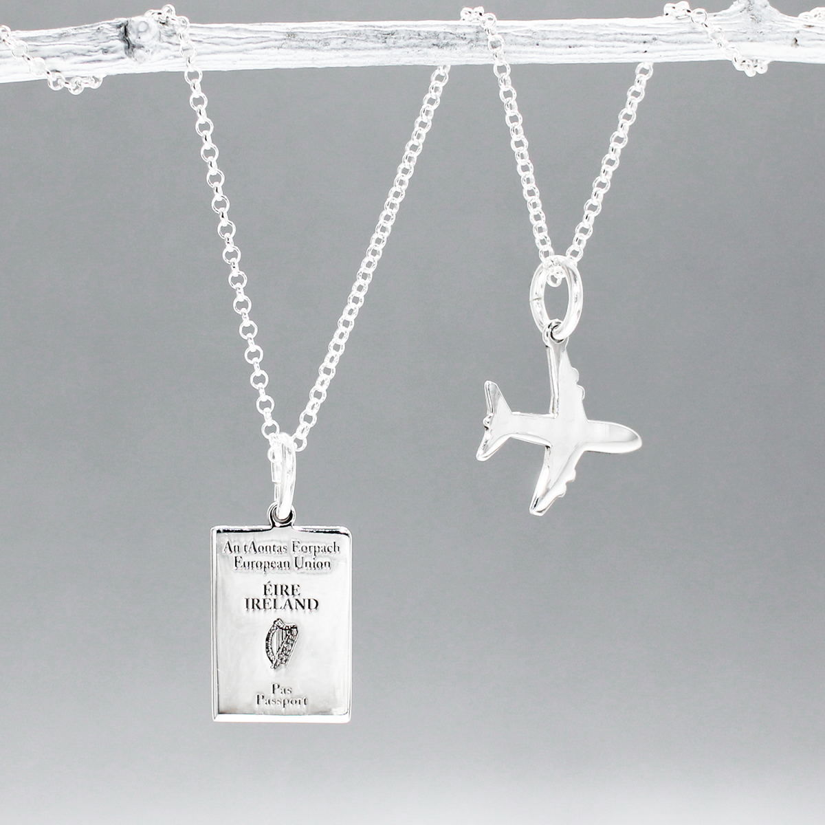 Irish Passport Replica Mini Silver Pendant with Mini Airplane Charm Pendant by Croí Kinsale Jewellery.  The passport measures 10 millimeters wide by 14 millimeters high, while the airplane charm measures 14 millimeters wide by 14 millimeters high. The bail fits up to a 2.5 mm chain, offering versatility for different chain sizes. Whether you gift it to a wanderer or keep it as a timeless heirloom, this pendant is a symbol of Irish pride and wanderlust. Kinsale gift