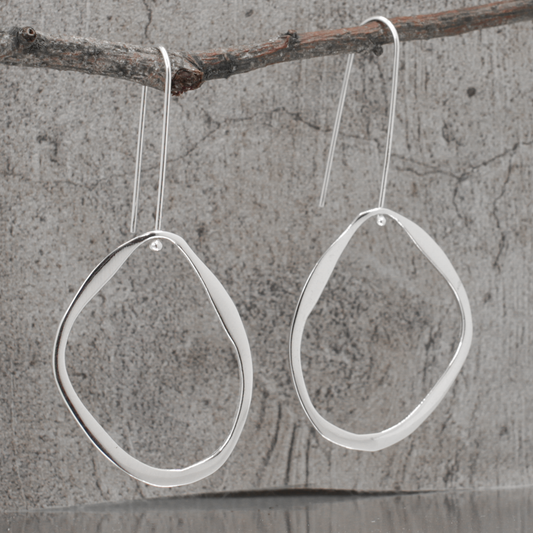 Indulge in the luxe beauty of these Saha Large Asymmetric Oval Droplet Silver Dangle Earrings! Forged from high-quality .925 sterling silver, they feature a stunning high-polished finish, measuring 37mm long and 31mm wide, while dangle 66mm from the top of the ear wire. Make any outfit shine with these statement earrings!