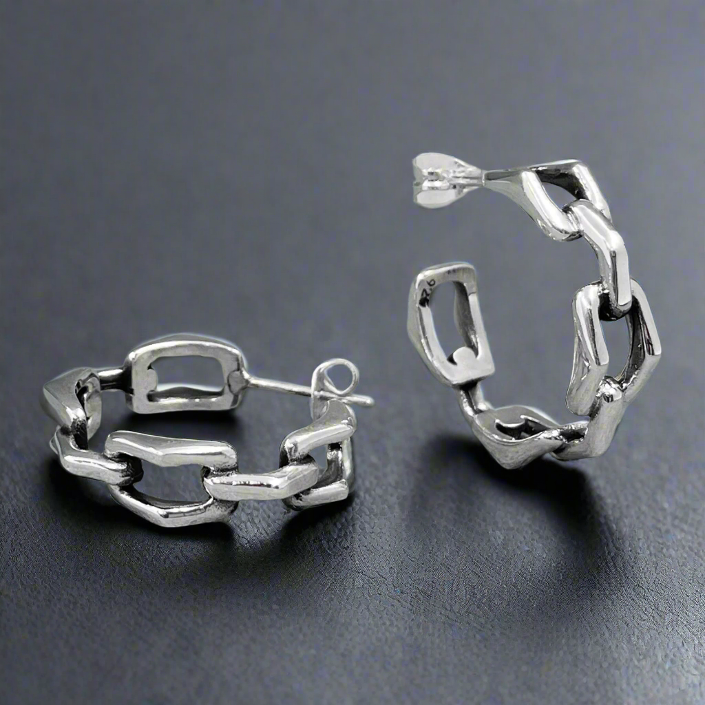 Showcase your individuality with the&nbsp;Saha Bridge Chain Large Hoop Silver Earrings. Inspired by triangulated chain links, these handcrafted sterling silver hoops blend modern design with timeless elegance. Their bold yet versatile style makes them the perfect accessory for any occasion, whether you're dressing up or down. Ireland silver jewellery 