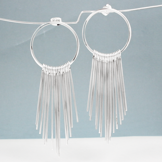 Saha - RADA Cascade Long Hoop Silver Earrings - Stud. These earrings command attention with their impressive dimensions: the hoop measures 28mm in diameter by 1.5mm thick, or roughly 1 1/16 inches by 1/16 inches thick. Extending gracefully at 75mm from the top of the ear wire, they make a striking statement.