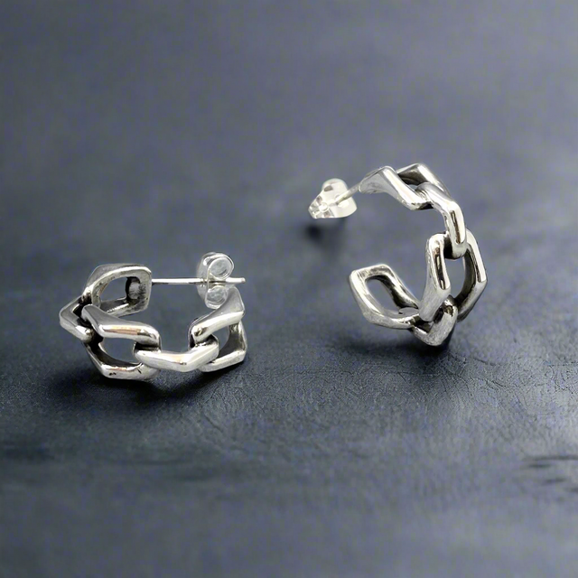 Express your style with the&nbsp;Saha Small Bridge Chain Hoop Silver Earrings. Handcrafted from sterling silver, these hoops feature a design inspired by triangulated chain links, blending modern sophistication with everyday wearability. Their compact size and sleek finish make them a versatile addition to your jewellery collection. Silver jewellery online ireland