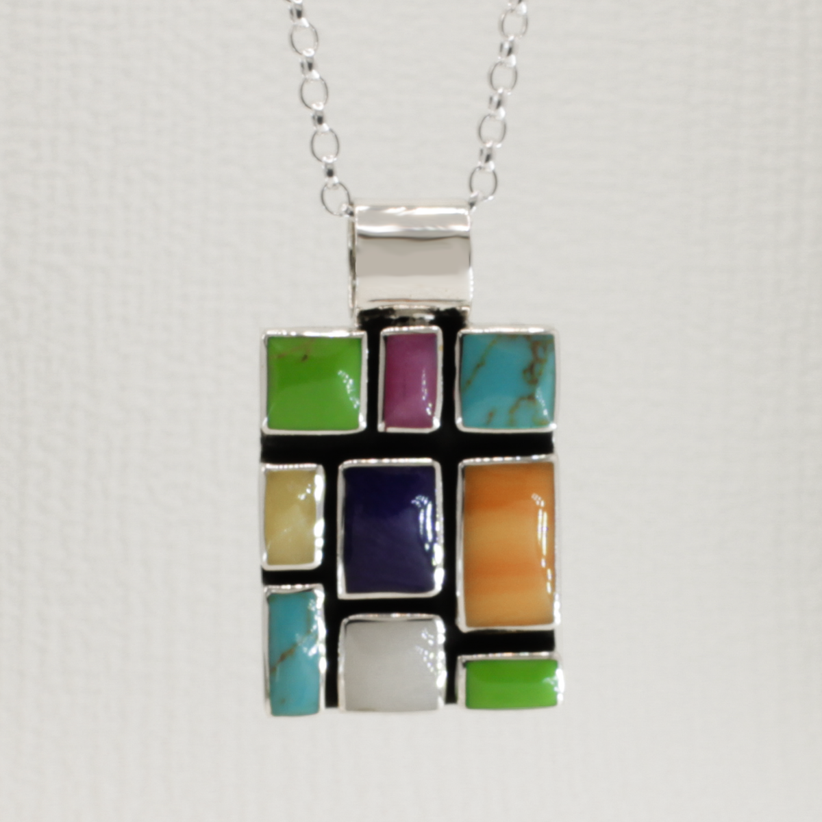 Sleveen's Rectangle With Multi-Coloured Mosaic Resin Silver Pendant is an exquisite piece of jewelry! Measuring 23mm in width, 30mm in length, and 3.5mm in depth, this pendant stands 40mm tall from its top bail for a truly impressive look. Crafted with .925 sterling silver, its bail can accommodate a chain up to 8mm, and comes with an adjustable 2.5mm silver roll chain that extends from 16" to 18".