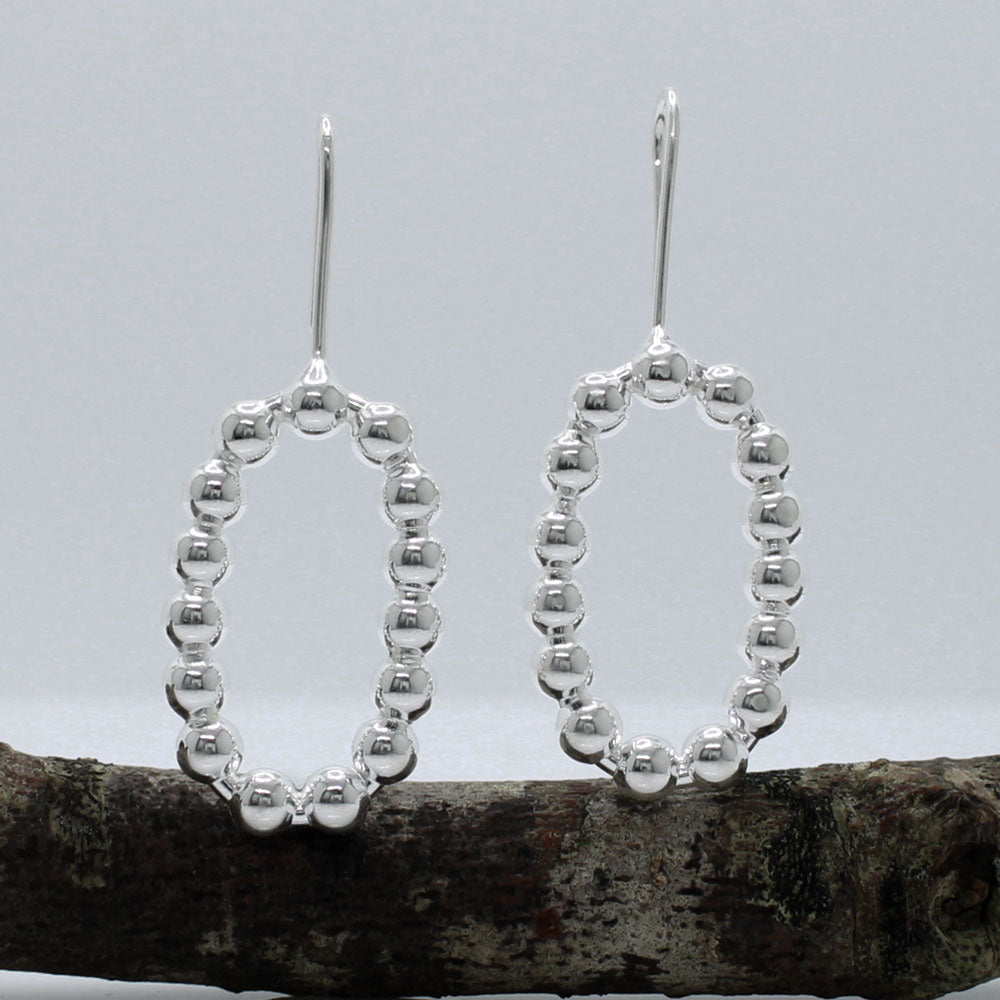 These handmade, sterling silver dangle earrings are a perfect blend of elegance and modern design. Features:  Oblong measures 17mm wide by 27mm high 4mm thick 40mm long from the top of the ear wire Made from sterling silver Handcrafted Highly polished finish for a brilliant shine Ideal for any occasion, these earrings add a touch of sophistication to any outfit.