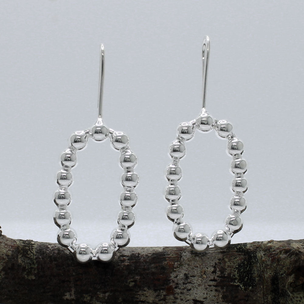 These handmade, sterling silver dangle earrings are a perfect blend of elegance and modern design. Features:  Oblong measures 17mm wide by 27mm high 4mm thick 40mm long from the top of the ear wire Made from sterling silver Handcrafted Highly polished finish for a brilliant shine Ideal for any occasion, these earrings add a touch of sophistication to any outfit.