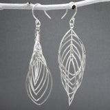 Tara - Mobile Multi Layered Leaf Shaped Wire Silver Earrings - Dangle  Design: Seven wire leaf-shaped pieces interconnected, creating an organic cascading leaves design Movement: Rotates when worn, adding whimsical and dynamic movement Features: Lightweight, highly polished silver Fastening: Sterling silver French wire Measurements: Width: 21 MM at its widest point Length: 66 MM from the top of the French wire