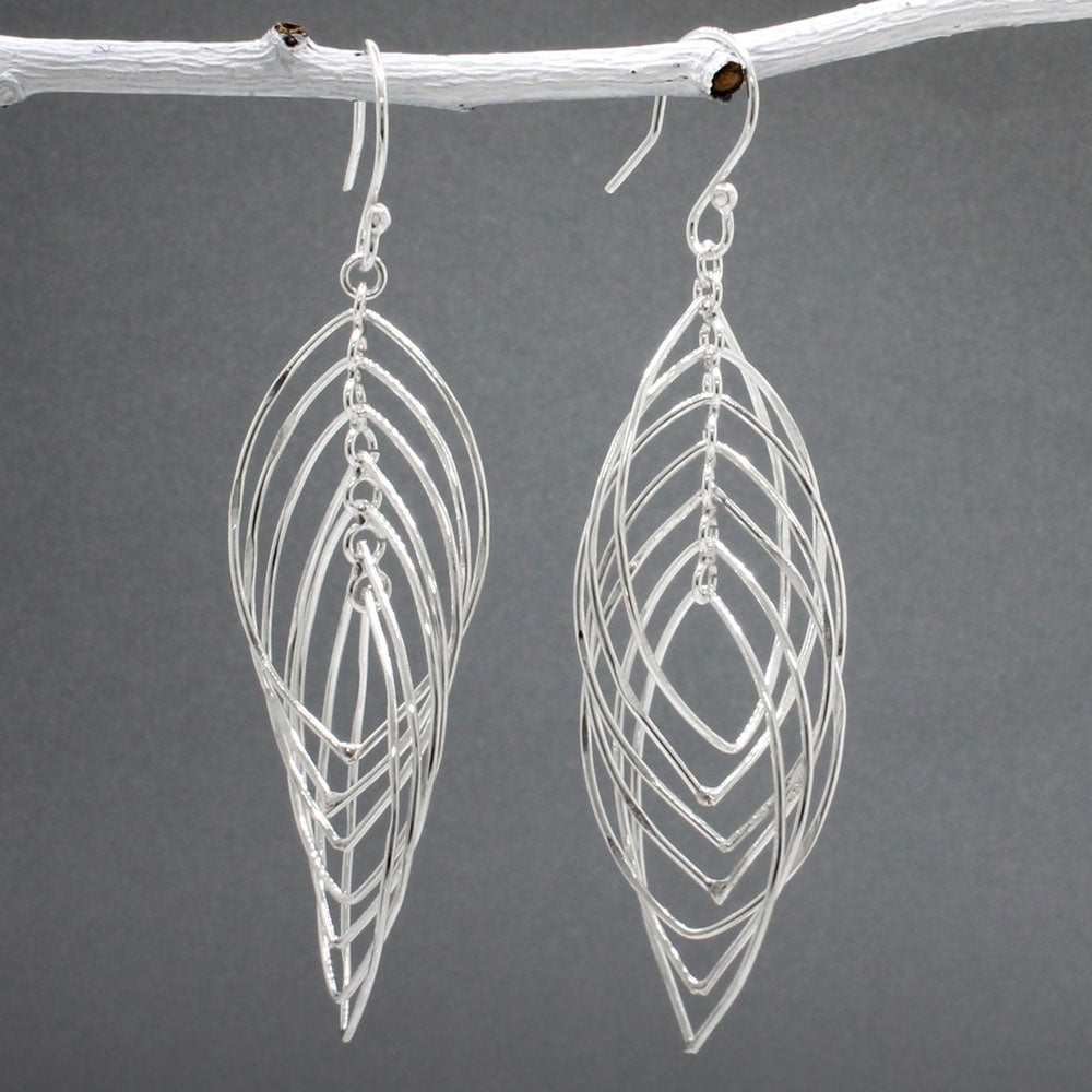 Tara - Mobile Multi Layered Leaf Shaped Wire Silver Earrings - Dangle  Design: Seven wire leaf-shaped pieces interconnected, creating an organic cascading leaves design Movement: Rotates when worn, adding whimsical and dynamic movement Features: Lightweight, highly polished silver Fastening: Sterling silver French wire Measurements: Width: 21 MM at its widest point Length: 66 MM from the top of the French wire