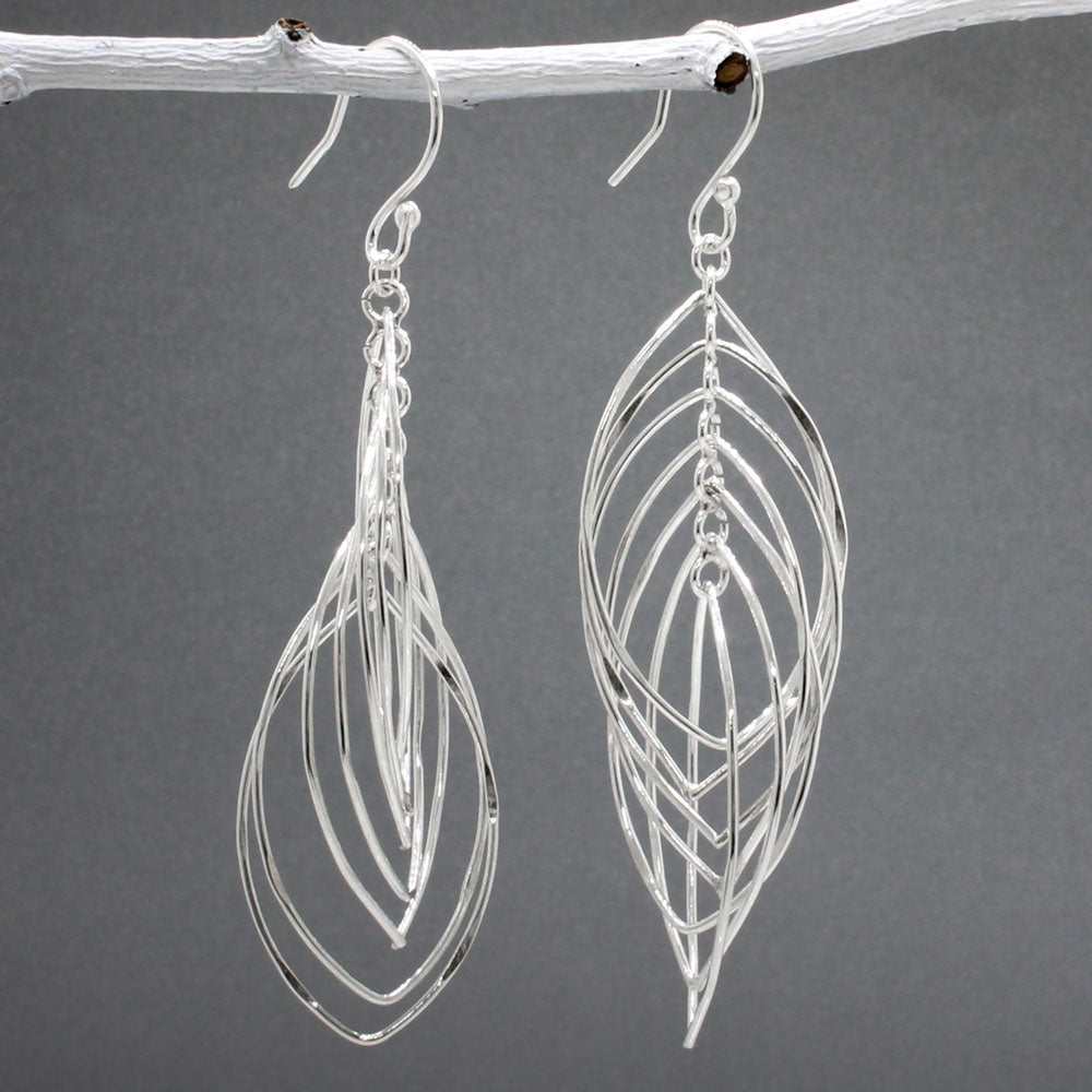 Tara - Mobile Multi Layered Leaf Shaped Wire Silver Earrings - Dangle  Design: Seven wire leaf-shaped pieces interconnected, creating an organic cascading leaves design Movement: Rotates when worn, adding whimsical and dynamic movement Features: Lightweight, highly polished silver Fastening: Sterling silver French wire Measurements: Width: 21 MM at its widest point Length: 66 MM from the top of the French wire