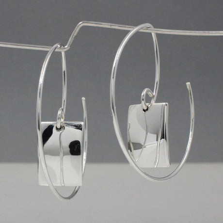 Artemis - Small Rectangle Hammered Reverse Hoop Silver Earrings Curated and designed by Emilio Sotelo Jewelry for Croi Kinsale Jewellery in Kinsale West Cork Ireland Europe. Find exceptional handmade silver and gold jewellery at affordable prices for birthday gifts and Christmas presents. Handcrafted Silver jewelry. The best affordable jewellery