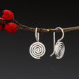 Aran - Swirl Disc Silver Earrings - Dangle Curated and designed by Emilio Sotelo Jewelry for Croi Kinsale Jewellery in Kinsale West Cork Ireland Europe. Find exceptional handmade silver and gold jewellery at affordable prices for birthday gifts and Christmas presents. Handcrafted Silver jewelry. Find the best affordable jewellery