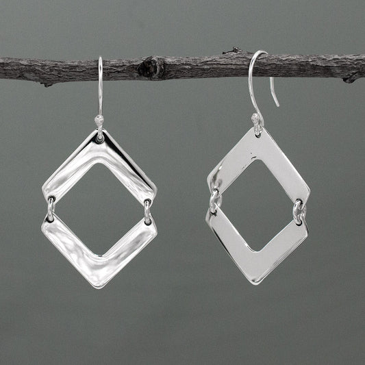 Experience elegance and style with Nathalia - Rhombus Silver Earrings. Measuring 33mm long by 23mm wide (1 5/16 inches by 15/16 inches), these dangle earrings are a stunning addition to any jewellery collection. Made of .950 sterling silver with a high polished finish and featuring a french wire, they hang 1 3/16 inches from the top of the ear for a captivating look.