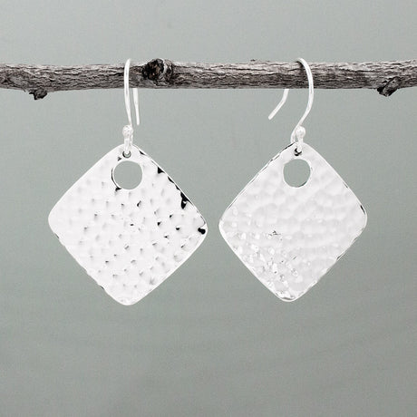 Nathalia - Rhombus Off-Center Dot Hammered Silver Earrings. With dimensions of 29mm long by 29mm wide, or roughly 1 1/4 inches square, they offer a bold yet elegant presence. The off-center dot design adds a unique flair to their hammered silver finish.