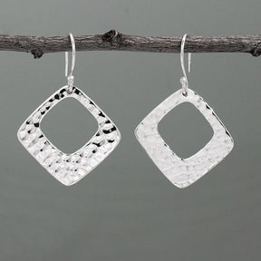 At 29mm x 29mm in size, featuring a 1 1/4 inch length and width, and a 1 11/16 inch drop from the ear wire, these Nathalia's Rhombus With Off-Center Hammered Silver Earrings - Dangle are made of .950 sterling silver with a stunning hammered finish. With sterling silver French wire.