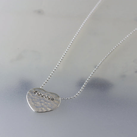 Croi - Miller Heart Hammered Silver Pendant Curated and designed by Emilio Sotelo Jewelry for Croi Kinsale Jewellery in Kinsale West Cork Ireland Europe. Find exceptional handmade silver and gold jewellery at affordable prices for birthday gifts and Christmas presents. Find Irish designers and makers. Beautiful jewellery shop located in Kinsale, Co. Cork.