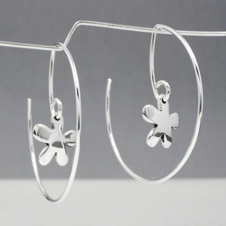 Discover the signature design of Emilio Sotelo Jewellery with these Moineir - Small Daisy Reverse Hoop Silver Earrings! Measuring 12 MM long and 12 MM wide, these earrings are made with .950 sterling silver and are sure to make a statement. Simply insert the earring from the back of your earlobe and work forward to effortlessly showcase these dimensional silver hoop earrings from any angle. Experience the beauty of these unique and stunning earrings for yourself.